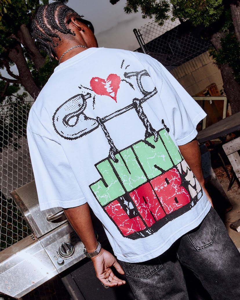 Person wearing a white t-shirt with colorful graphics and text.